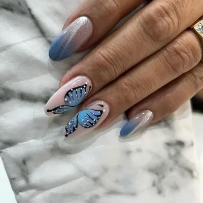 A close-up of our incredibly detailed, hand-painted butterfly wing. We combine this with a blue ombré and cat eye effect for a truly magical manicure.