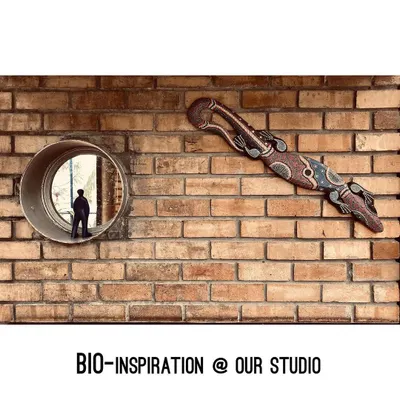 Bio-inspiration is everywhere in our studio. This tribal lizard art, mounted on an exposed brick wall next to a circular window, reflects our love for nature, craft, and looking at the world from different perspectives.