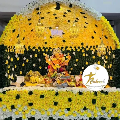 This grand floral makhar is one of our signature designs, using a dense arrangement of yellow, white, and green flowers with elegant hanging lanterns. This is the premium quality I promise for every Ganpati decoration.