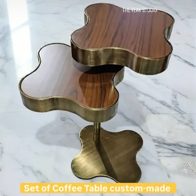 This custom-made set of coffee tables features a unique clover-like shape. The combination of a stainless steel structure in an antique brass finish and a walnut PU top creates a luxurious and eye-catching centerpiece.