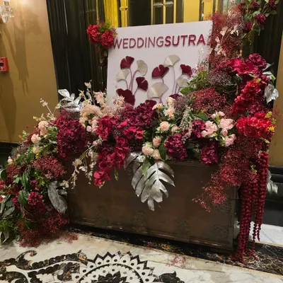The decor we created for the WeddingSutra Influencer Awards entrance. This lush floral installation in shades of deep red and blush, featuring the event's branding, welcomed the industry's top talent to the prestigious awards night.