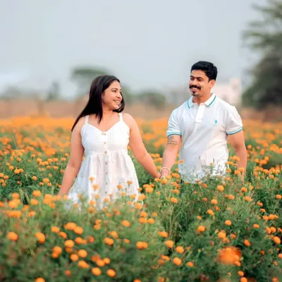 Walking hand-in-hand through a field of marigolds. For this nature-filled pre-wedding shoot, the goal was to create a feeling of pure, simple joy. The warm colors and the couple's easy smiles make this a perfect example of a romantic outdoor session.