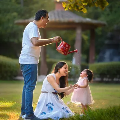 The best family photos come from genuine moments of fun. I love creating playful scenarios like this one, where a little splash from a watering can leads to the most authentic laughter and joy.