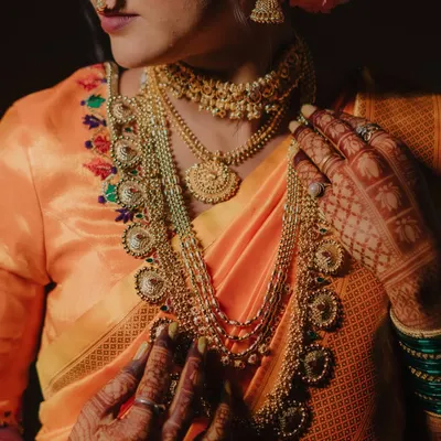 A detailed shot focusing on the bride's magnificent temple jewelry and the fine embroidery on her blouse, showcasing the artistry of her bridal look.