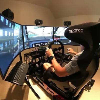 A high-end racing simulator featuring a triple-screen setup for a panoramic view of the track. This professional rig, complete with a Sparco racing seat and wheel, is the ultimate attraction for motorsport enthusiasts.