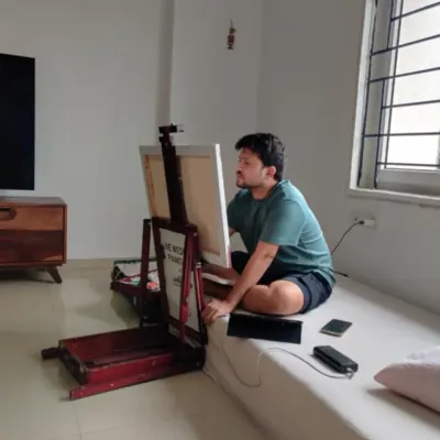 A quiet moment of focus in our studio. Here, Vivek is working on a custom family painting, carefully studying the reference photos to get every detail just right.