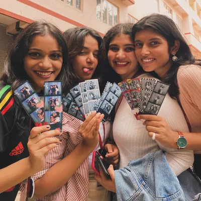 The ultimate souvenir from Cul Week at MCC! These students are showing off their collection of photo strips, each one a memory of the fun they had. This is what it's all about: instant, shareable joy.