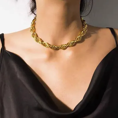A bold and beautiful gold-toned rope chain necklace, worn to show its striking texture and shine. This statement piece is made from high-quality materials to ensure it lasts.