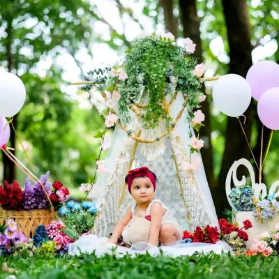 A fairytale scene in the park. This outdoor setup combines a floral teepee and balloons to create a magical first birthday portrait.