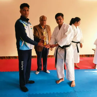 Presenting an award to a student who achieved his black belt. This is a significant milestone in any martial artist's journey.