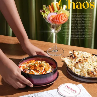 This lifestyle shot for a restaurant menu captures the moment a dish is served. Including hands in the frame makes the scene feel more dynamic and relatable, inviting the viewer to imagine themselves at the table.