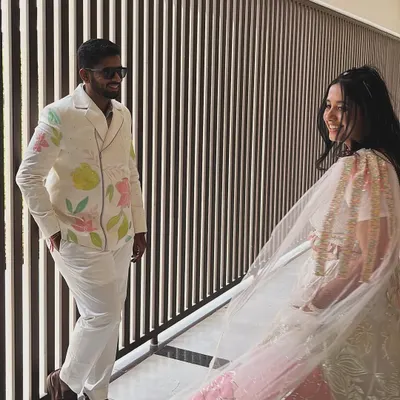 A beautiful moment captured between the bride and groom. I loved creating his custom carnival outfit, with abstract florals that subtly matched her beautiful lehenga, making their look truly unique and personal.
