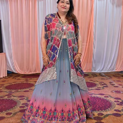The mother of the bride looking radiant for her daughter's mehendi. We chose a vibrant, multi-colored lehenga with a stylish jacket and paired it with a bold necklace for a look that is both fun and elegant.