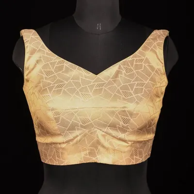 A studio shot of our golden brocade blouse with a V-neck and a subtle geometric pattern. This view shows the precise cut and construction.