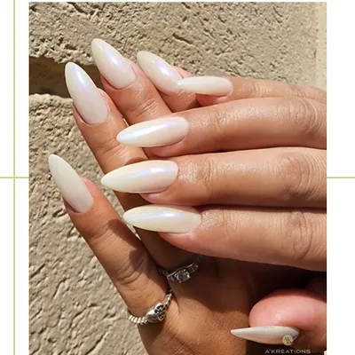 The definition of classic elegance. These long, almond-shaped nail extensions are finished with a pearlescent white polish that gives a beautiful, iridescent sheen in the light.