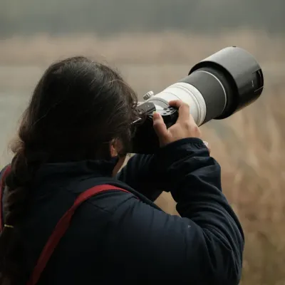 Me with a telephoto lens, focused on capturing a distant subject. This is typical for my wildlife or candid street photography work.