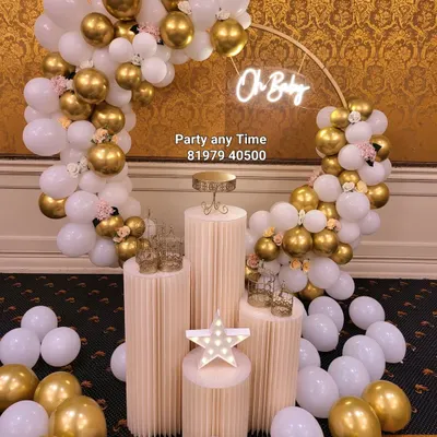 An elegant 'Oh Baby' setup for a baby shower. The white and gold chrome balloons with small flower details create a sophisticated and celebratory look.