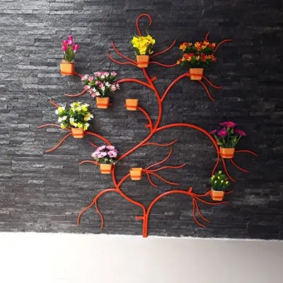 This is a custom wall art piece I created that also serves as a vertical planter. The metal tree-shaped structure is a space-saving solution for plant lovers, allowing you to display multiple small pots in an artistic way.