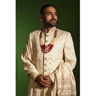 A detailed view of the craftsmanship on my ivory chikankari sherwani. The texture of the hand embroidery and the quality of the raw silk fabric are central to creating this regal piece, perfect for a discerning groom.