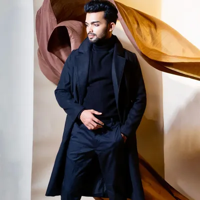 I styled this look to create a powerful and timeless statement. The sharp lines of the black overcoat and turtleneck, combined with the dynamic fabric backdrop, produce a high-fashion portrait ideal for a model's portfolio.