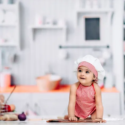 This little chef is ready to cook up some fun in our adorable kitchen-themed studio setup. We provide the hat, apron, and props for a picture-perfect session.