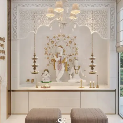 A luxurious and serene pooja room crafted from white marble with delicate floral inlay work. This space is designed for extended prayer and features a statement chandelier, traditional hanging lamps, and integrated seating.