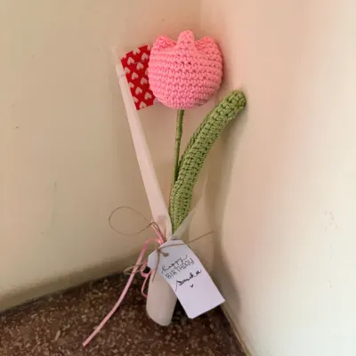A single pink crochet tulip with a personalized "Happy Birthday" tag. It’s a simple, sweet, and personal gift that shows you care.