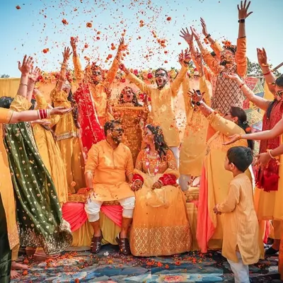 The quintessential Haldi moment. We love capturing the energy of friends and family as they shower the couple with love and flower petals, creating a memory that lasts a lifetime.