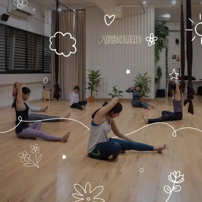 Participants warm up during an aerial silk experience in Mumbai. Our sessions begin with foundational stretches to prepare the body for graceful movement in the air.