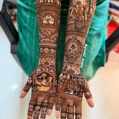 A full bridal design dedicated to the divine love of Radha and Krishna. One arm features their portrait, while the other depicts symbols associated with them, like cows and palace gardens.