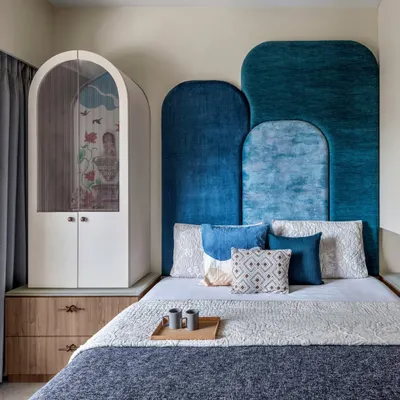 Designing for Mumbai homes pushes your creativity. In this guest bedroom, I managed to fit a full-sized bed, a mandir, wardrobes, and extra storage, all while creating a special look with a bold blue headboard.