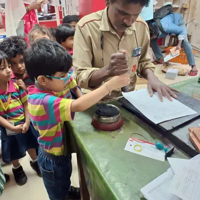 A student gets a hands-on lesson in how mail is processed during a field trip to the local post office. He is learning how to use the official seal to stamp letters.