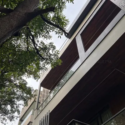 An upward view of a modern residence we designed, highlighting the cantilevered forms and the mix of materials. The warmth of the wood-paneled soffits contrasts with the clean white structure and glass railings, creating a dynamic and timeless facade.