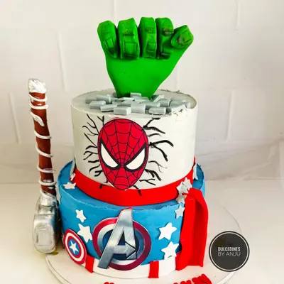 An action-packed two-tier Avengers cake. Featuring a Hulk fist smashing through the top, Thor's hammer, and Captain America's shield, this cake is a dream for any young superhero fan.