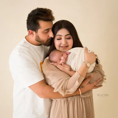A new family of three, wrapped in love. This portrait captures the quiet, tender moments right after a baby's arrival.