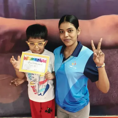 A proud moment. This young gymnast is thrilled to receive his certificate of achievement from his coach, a reward for all his hard work in class.