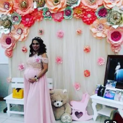 This backdrop features a full arch of handmade paper flowers in various sizes and shades of pink and peach over a sheer white curtain. I included a small white bench, a teddy bear, and a pink rocking horse to complete this cozy and elegant photo area.