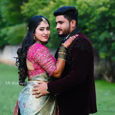 A romantic outdoor portrait of a couple. The bride's reception makeup features a soft glam look with defined eyes and a hairstyle of loose curls.