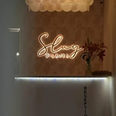 Welcome to Slay Pilates. This is where your transformation begins, from the moment you walk in and see our glowing reception desk.