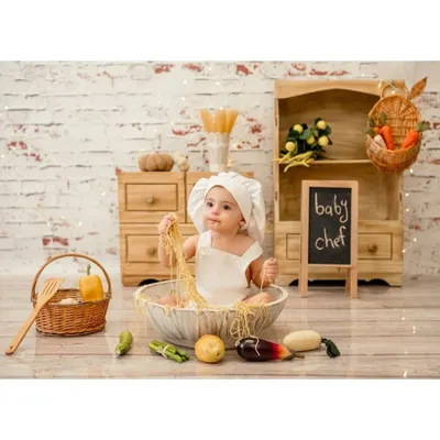 A little chef cooking up some fun. This baby is having a blast playing with spaghetti in our adorable miniature kitchen setup. It's a messy but memorable experience.