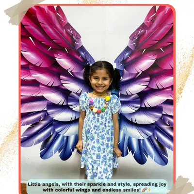 Every child is an angel at our studio. This student's bright smile perfectly complements our colorful wings mural, a favorite photo spot for everyone.