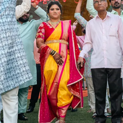 There's nothing like a perfectly draped Nauvari for a grand bridal entry. This bride is walking with confidence in a traditional yellow and pink dhoti-style drape, ready for her big moment.