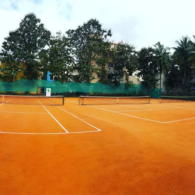 A wide view of our dual clay courts, offering ample space for the practical sessions included in our coach development programs.