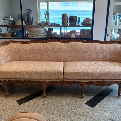 This classic sofa features a hand-carved wooden frame and is upholstered in a soft, textured pink fabric. It's a perfect example of how I blend traditional forms with contemporary textiles to create a timeless piece.