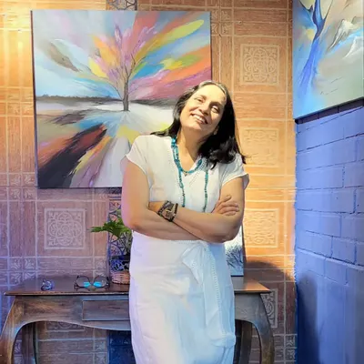 Artist Gurpreet Kaur, whose work blends oil and acrylics to create emotive landscapes, stands proudly with her art during her first solo exhibition at our gallery.