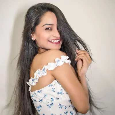 A picture-perfect smile. This clean studio portrait in a floral top captures a moment of pure, effortless joy.