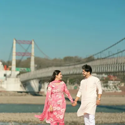 A simple, heartfelt moment of a couple in traditional attire walking hand-in-hand, with the iconic Ram Jhula bridge of Rishikesh in the background. It’s these quiet, authentic scenes that I love to capture.