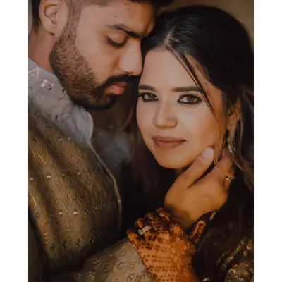 A beautiful and intimate close-up of the couple after their ring ceremony. The groom's hand gently holding her face, and her direct gaze at the camera, creates a powerful and romantic portrait.