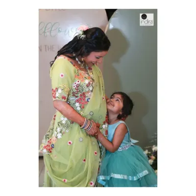 A beautiful, candid moment between a mother-to-be and her daughter, who is looking up at her mom and the baby bump with love and curiosity.