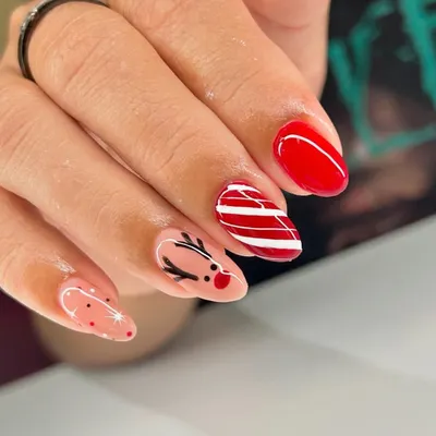 Getting into the holiday spirit with this cute Christmas-themed manicure. We hand-painted a little reindeer, a candy cane stripe, and some festive sparkles.